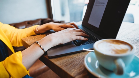 Woman on laptop in coffee shop